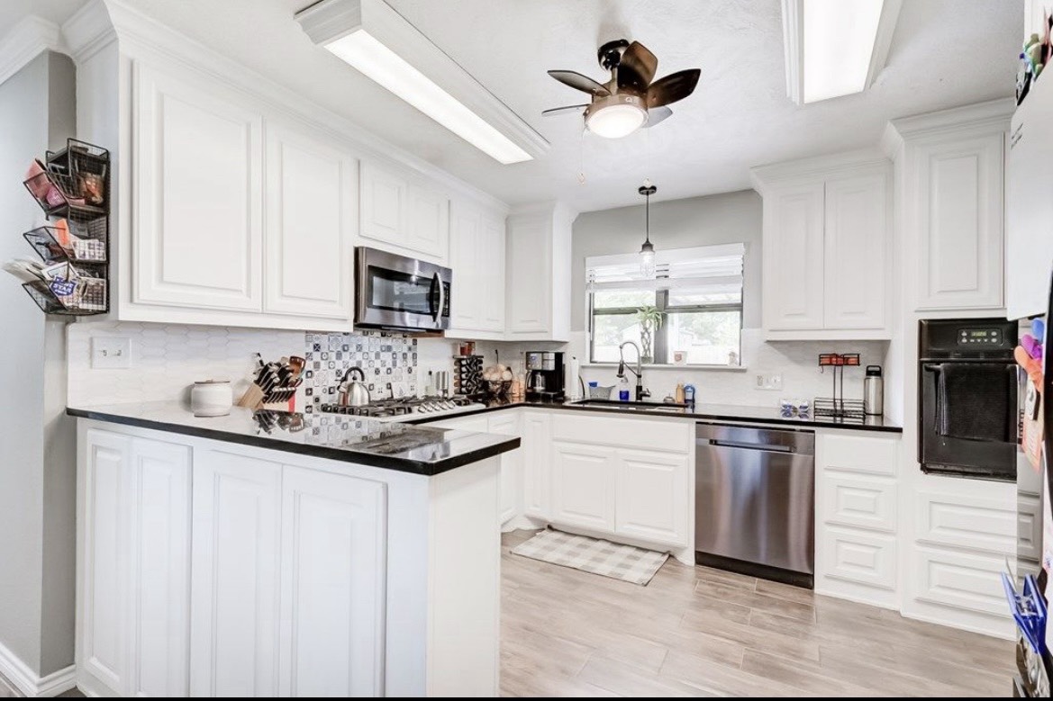 3103 Monroe Street Nederland, TX 77627 - Photo 2 of 11 a kitchen with stainless steel appliances granite countertop a stove a sink and a refrigerator
