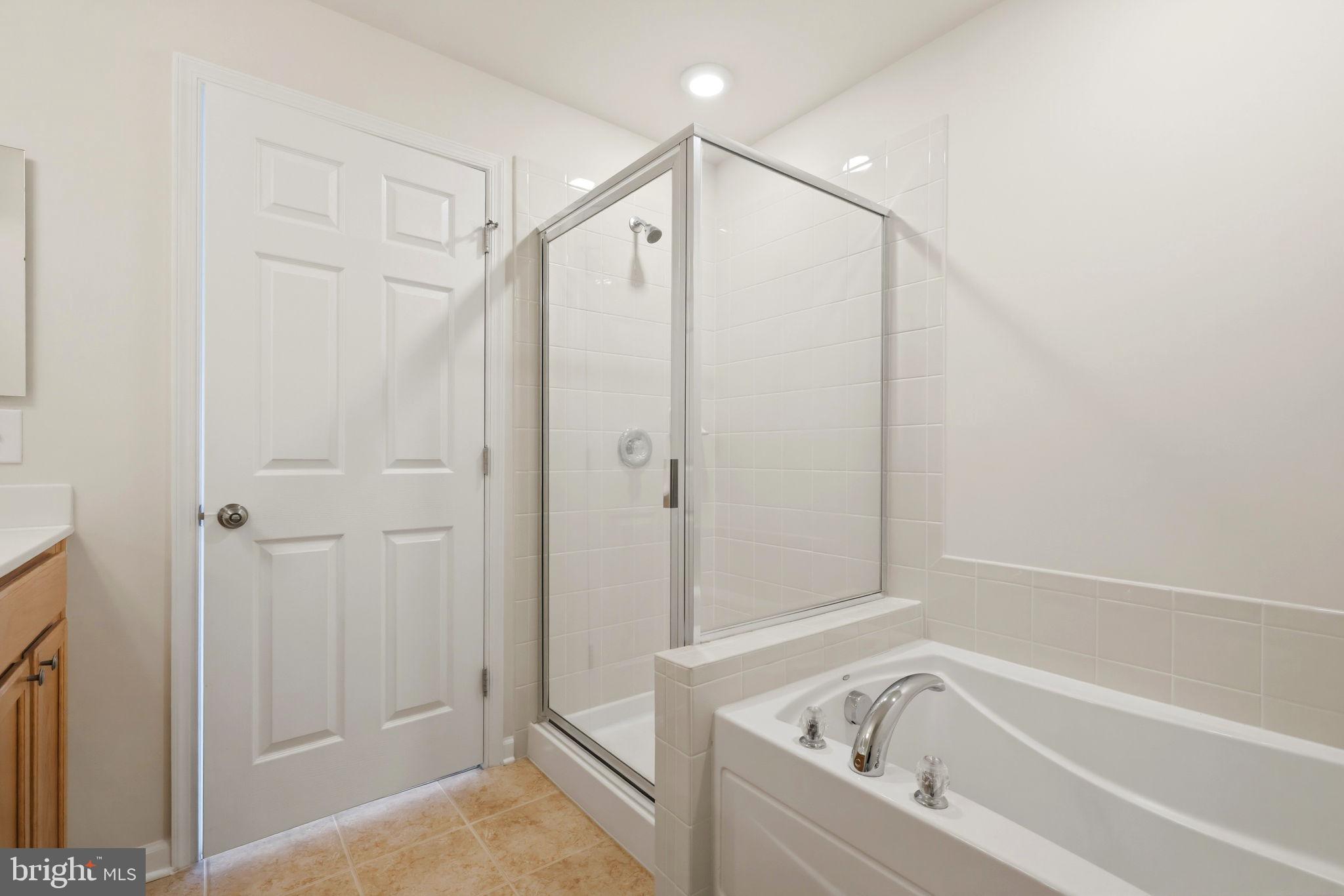 43487 Town Gate Square Chantilly, VA 20152 - Photo 32 of 56 a bathroom with a bathtub and a shower