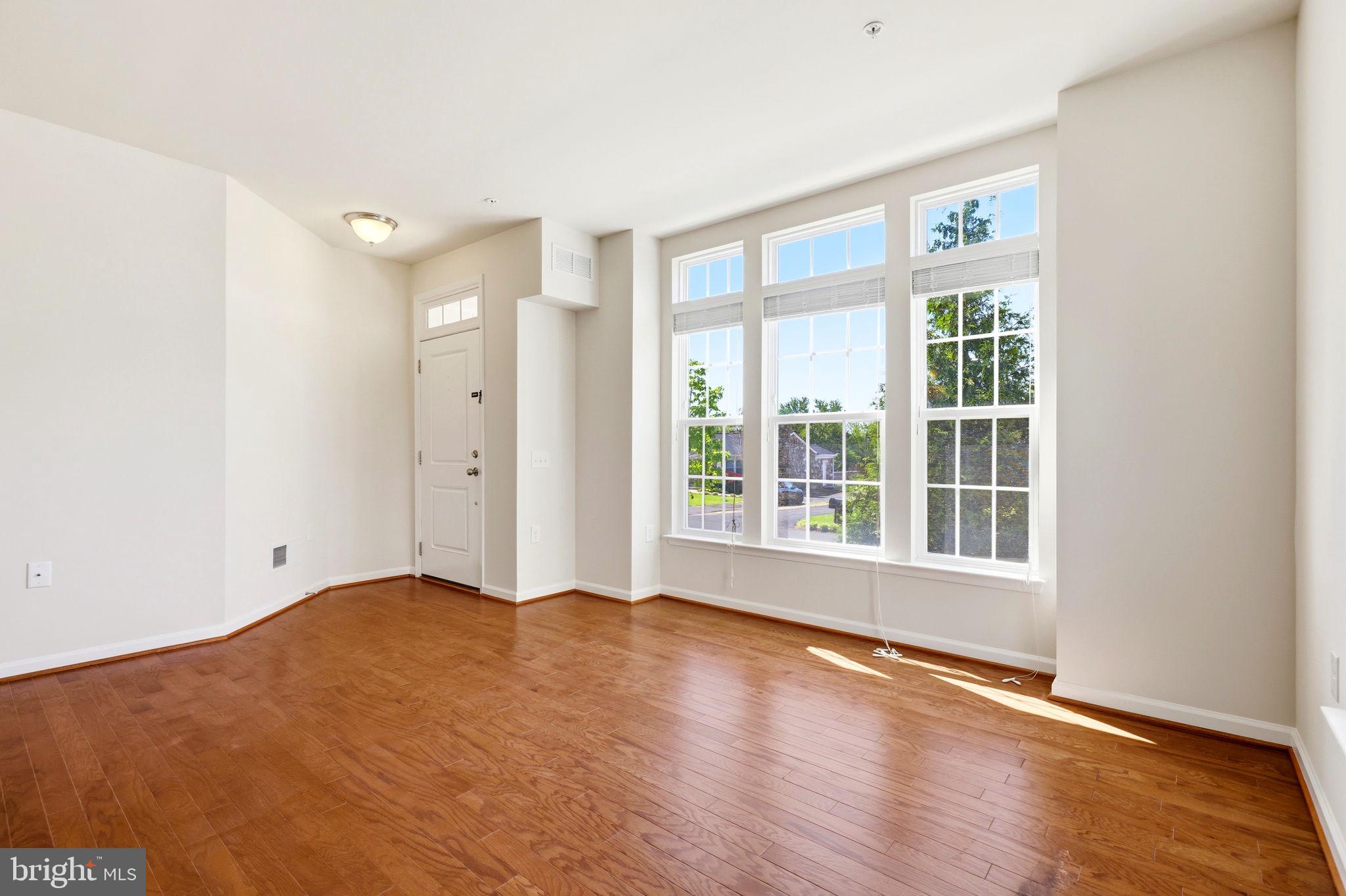 43487 Town Gate Square Chantilly, VA 20152 - Photo 6 of 56 a view of an empty room with wooden floor and a window