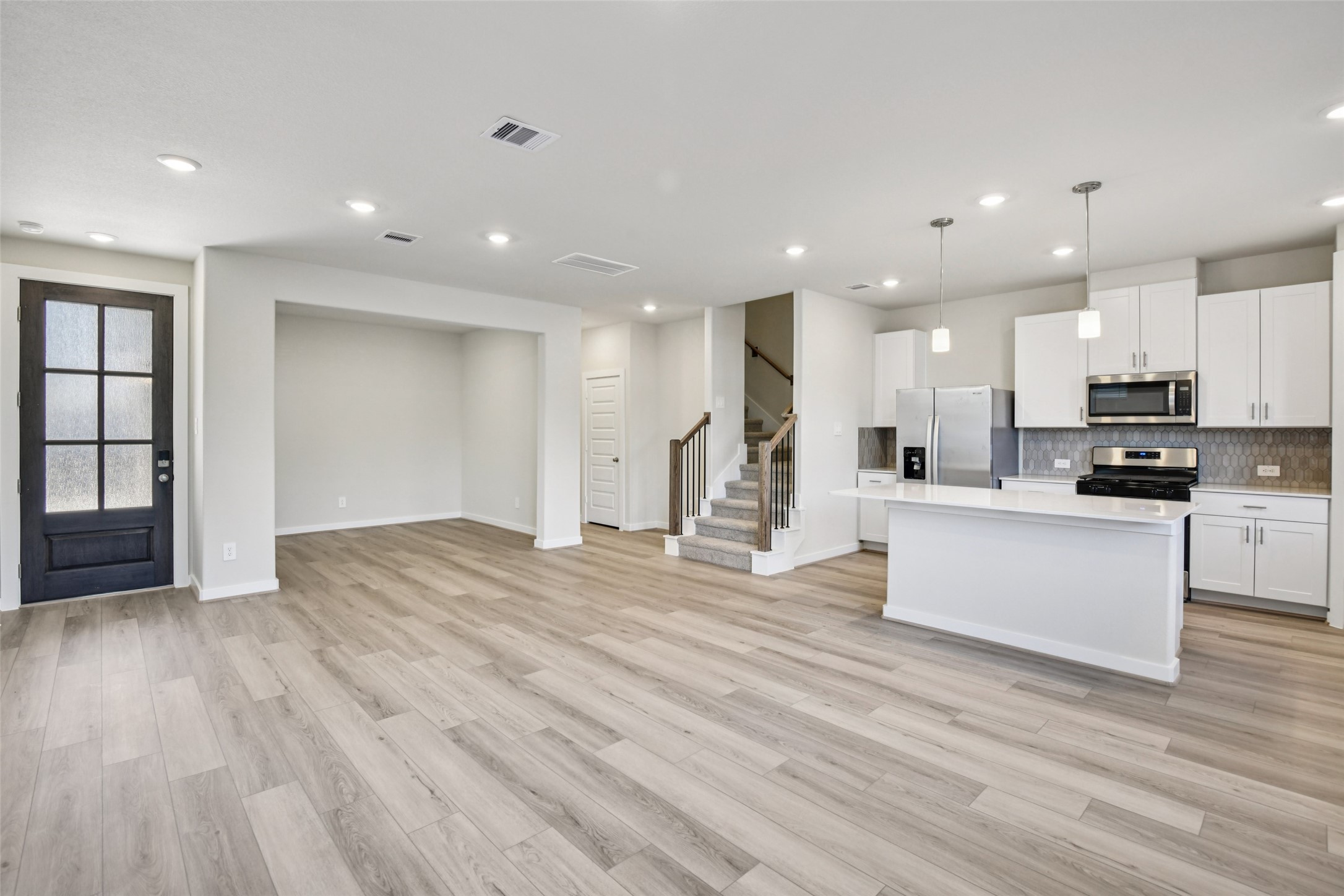 10012 Rustic Charm Street Houston, TX 77080 - Photo 4 of 45 a view of kitchen with kitchen island wooden floors appliances and cabinets
