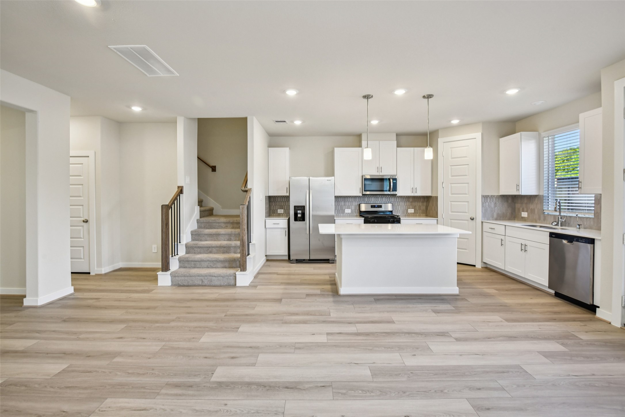 10012 Rustic Charm Street Houston, TX 77080 - Photo 7 of 45 a large kitchen with stainless steel appliances kitchen island granite countertop a stove a sink a refrigerator and white cabinets