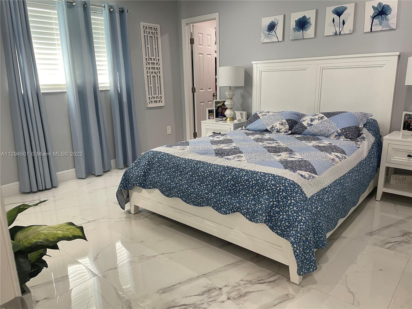 2222 Southwest 138th Avenue Miami, FL 33175 - Photo 14 of 27 a bedroom with a bed lamp and a large mirror on the dresser