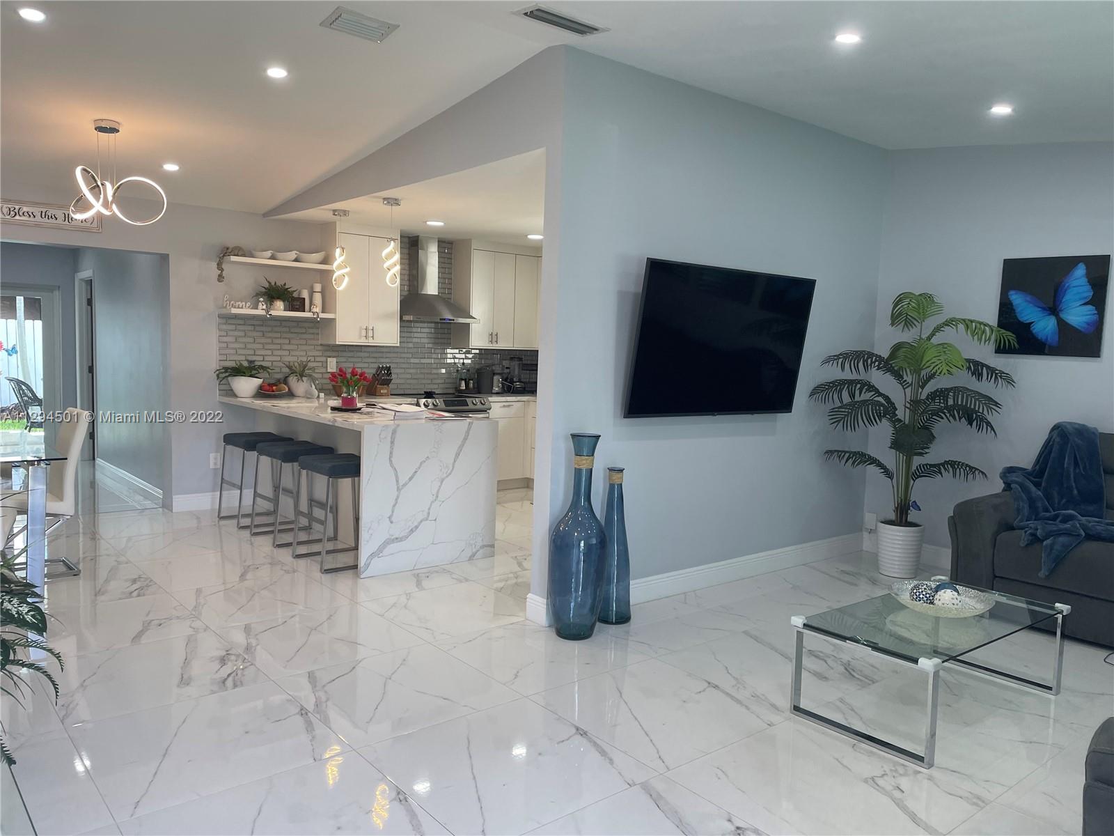 2222 Southwest 138th Avenue Miami, FL 33175 - Photo 24 of 27 a kitchen with stainless steel appliances kitchen island granite countertop a table and chairs in it