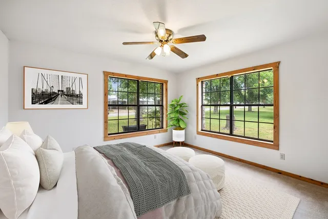 a spacious bedroom with a bed and a large window