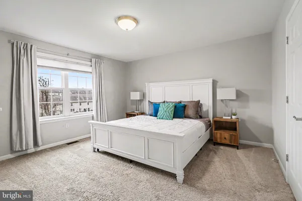 a spacious bedroom with a bed and window