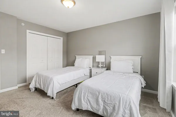 a bedroom with two beds and a lamp