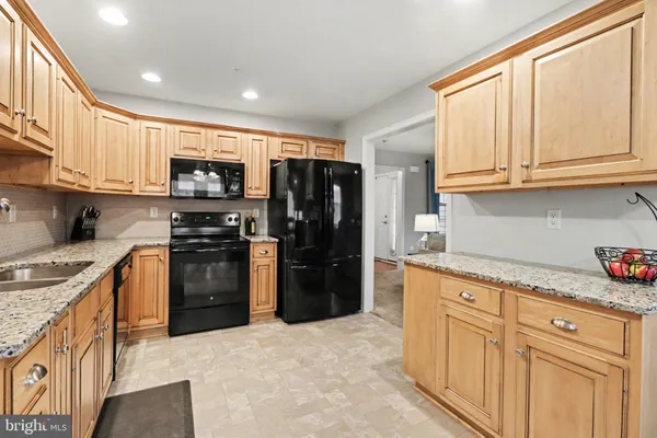 a kitchen with kitchen island granite countertop a refrigerator stove and sink