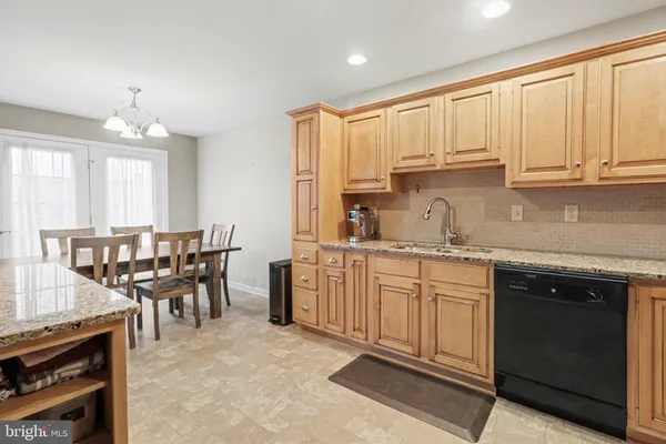 a kitchen with appliances cabinets and chair