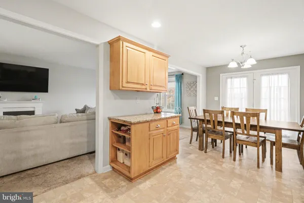a large white kitchen with cabinets a sink a window and a couch