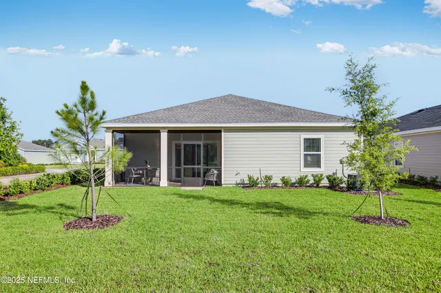 a front view of a house with a yard and trees