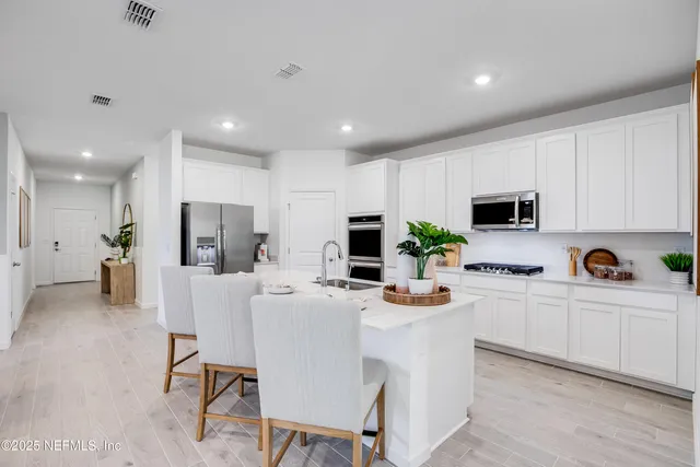 a kitchen with a faucet a sink and a flat screen tv