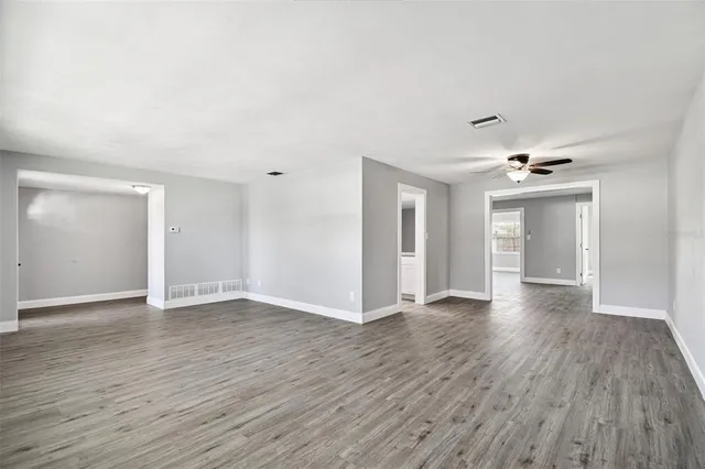 an empty room with wooden floor a ceiling fan and closet