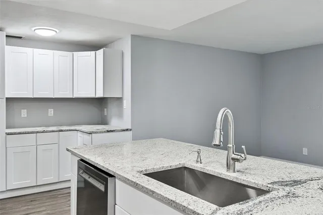a large kitchen with stainless steel appliances a sink and a refrigerator