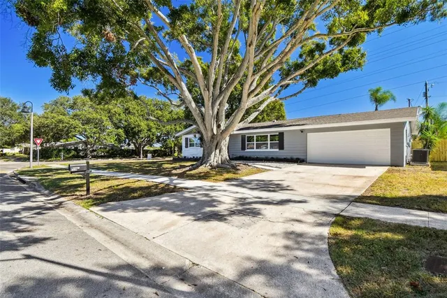 a front view of a house with a yard and potted plants
