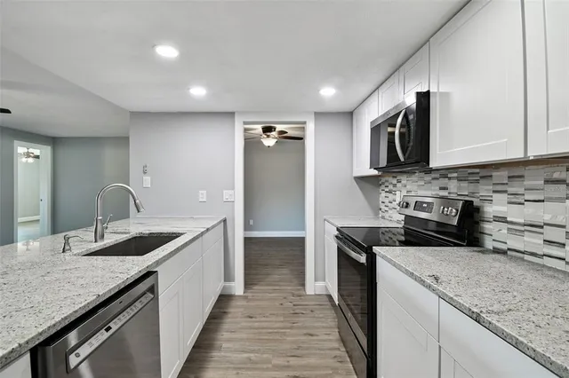 a view of a livingroom with wooden floor and a ceiling fan