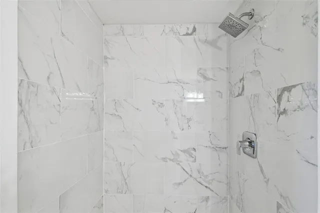 an empty room with wooden floor chandelier fan and windows