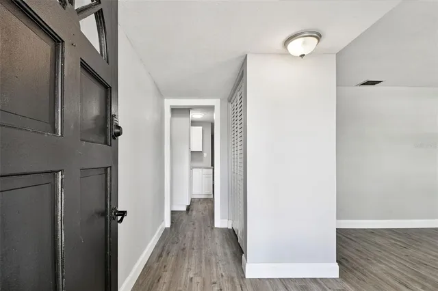 an empty room with wooden floor and window