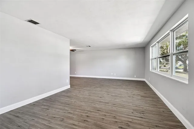 a view of empty room with wooden floor
