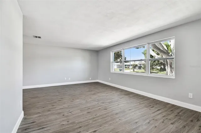 a view of an empty room with wooden floor