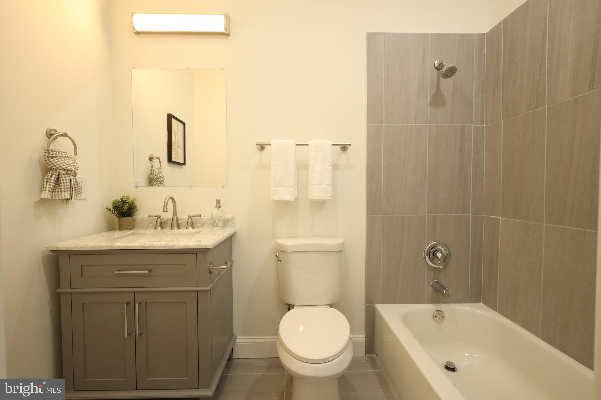 3316 North Market Street Wilmington, DE 19802 - Photo 29 of 40 a bathroom with a granite countertop sink a toilet and shower