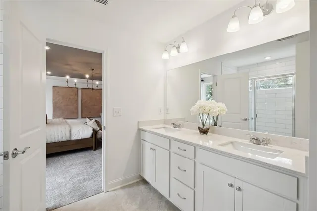 a en suite bathroom with a double vanity sink and a mirror