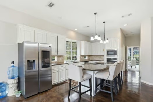 108 Inverness Conroe, TX 77356 - Photo 11 of 29 a kitchen with refrigerator a sink and chairs