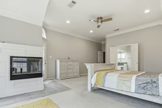 108 Inverness Conroe, TX 77356 - Photo 17 of 29 a bedroom with a large bed and a chandelier