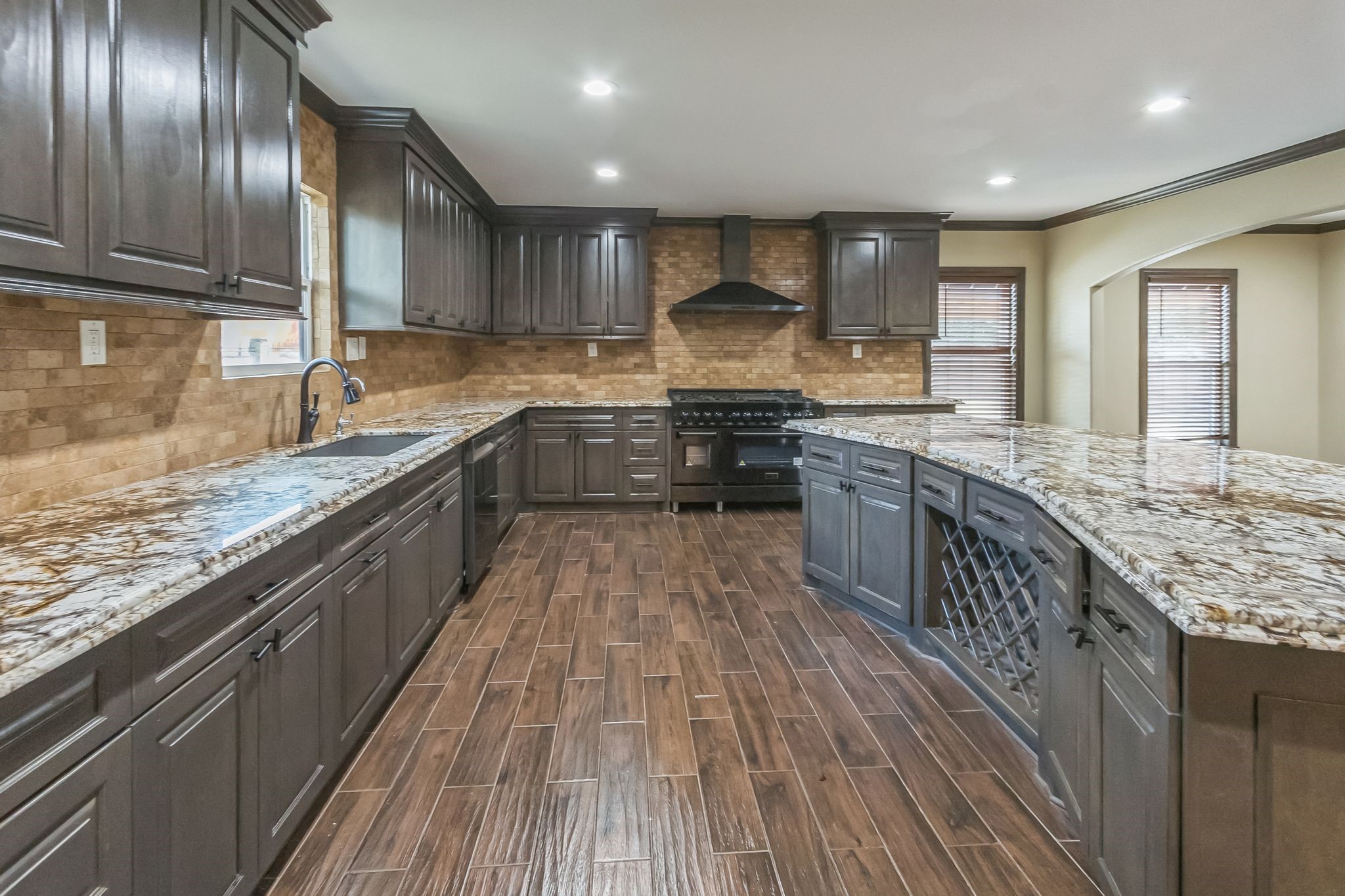 24578 Derry Street Hempstead, TX 77445 - Photo 16 of 50 Large range with a vent hood, built-in oven, and a dishwasher. The warm-toned tile flooring complements the overall aesthetic, creating an inviting cooking space.