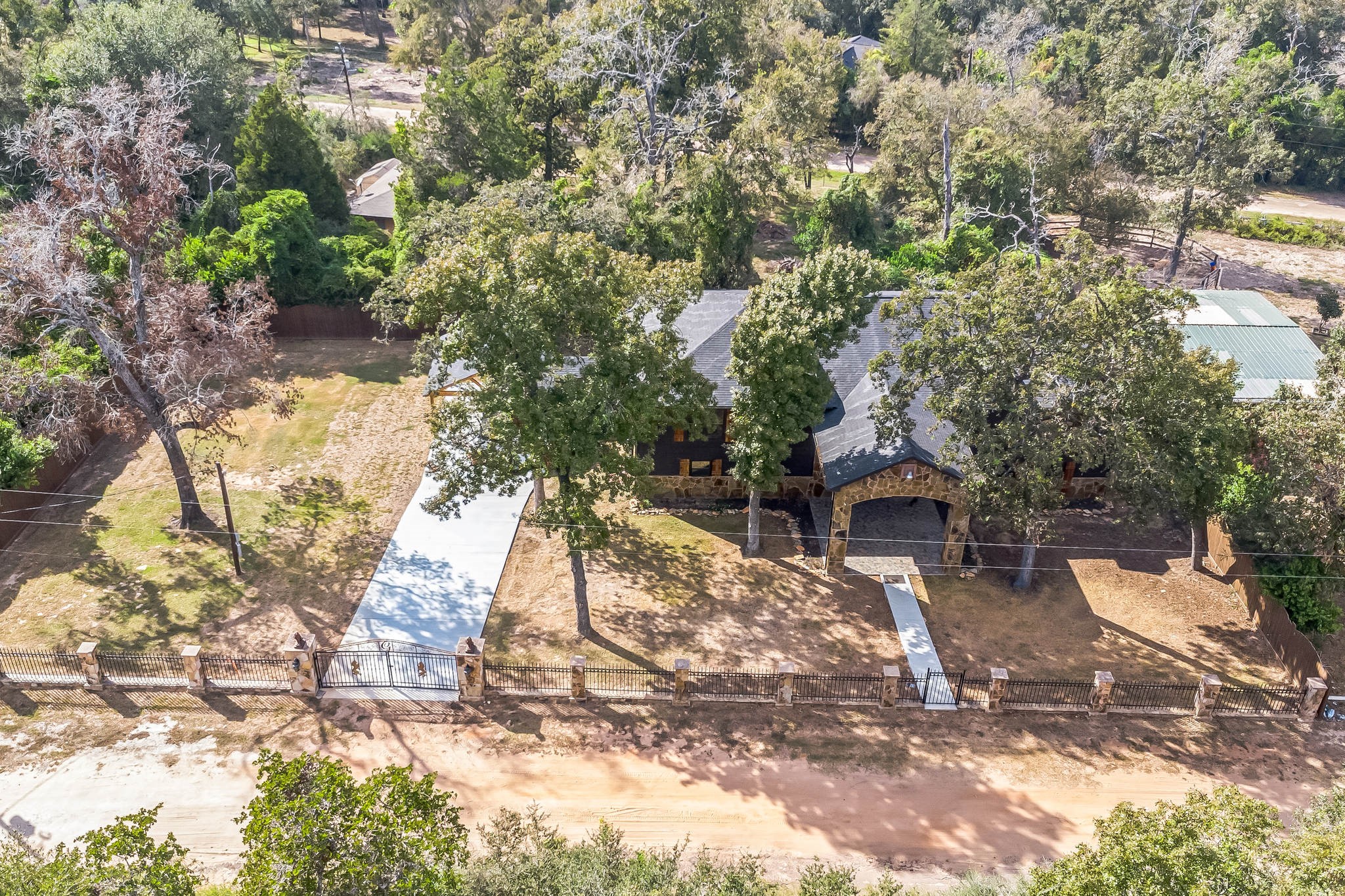 24578 Derry Street Hempstead, TX 77445 - Photo 3 of 50 Hempstead living offers privacy and natural beauty. The property features a spacious yard, a gated entrance, and a long driveway leading to the house. Perfect for those seeking a serene, wooded setting.