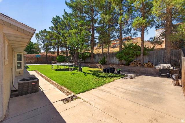 1690 Maplewood Way St. George, UT 84790 - Photo 15 of 17 Expansive backyard retreat featuring a manicured lawn, mature pine trees providing natural shade, concrete patio hardscaping, and wooden privacy fencing