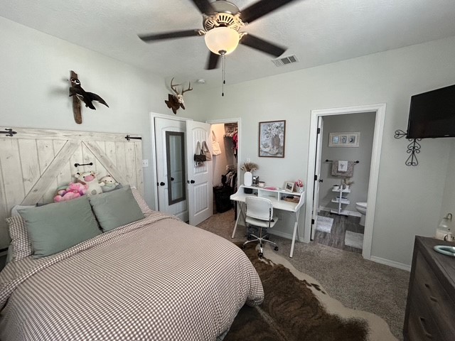 6942 Halter Loop College Station, TX 77845 - Photo 18 of 28 Bedroom with carpet flooring, a spacious closet, ceiling fan, and ensuite bath