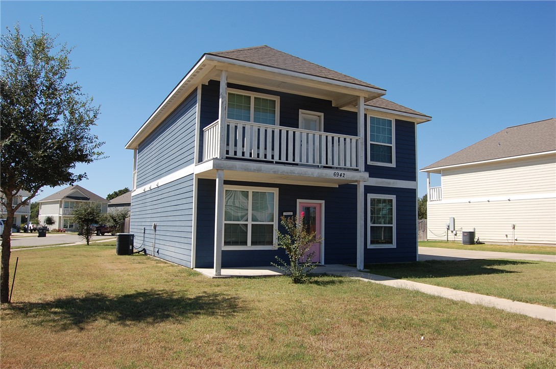 6942 Halter Loop College Station, TX 77845 - Photo 2 of 28 Traditional home featuring a front yard, a balcony, and a shingled roof