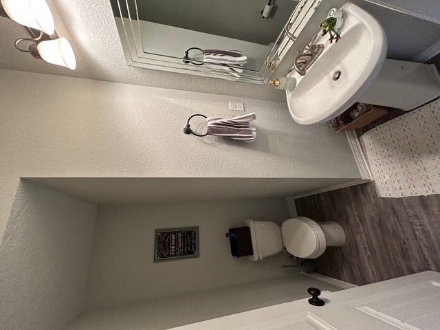6942 Halter Loop College Station, TX 77845 - Photo 22 of 28 Bathroom with dark wood finished floors, a textured wall, and a textured ceiling