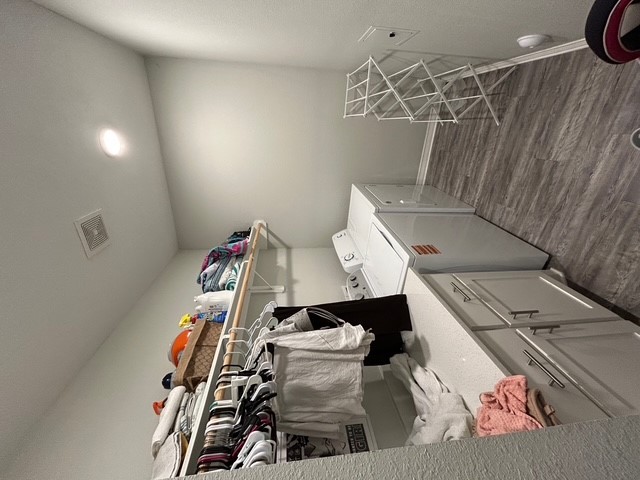 6942 Halter Loop College Station, TX 77845 - Photo 23 of 28 Washroom featuring dark wood finished floors, washer and dryer, and cabinet space