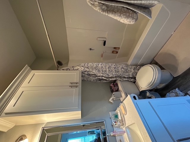 6942 Halter Loop College Station, TX 77845 - Photo 10 of 28 Bathroom with vanity, shower / tub combo with curtain, and dark wood-style flooring