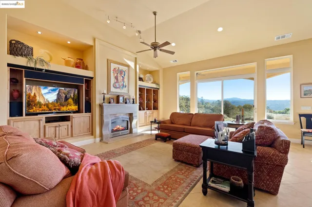 a living room with furniture kitchen view and a chandelier