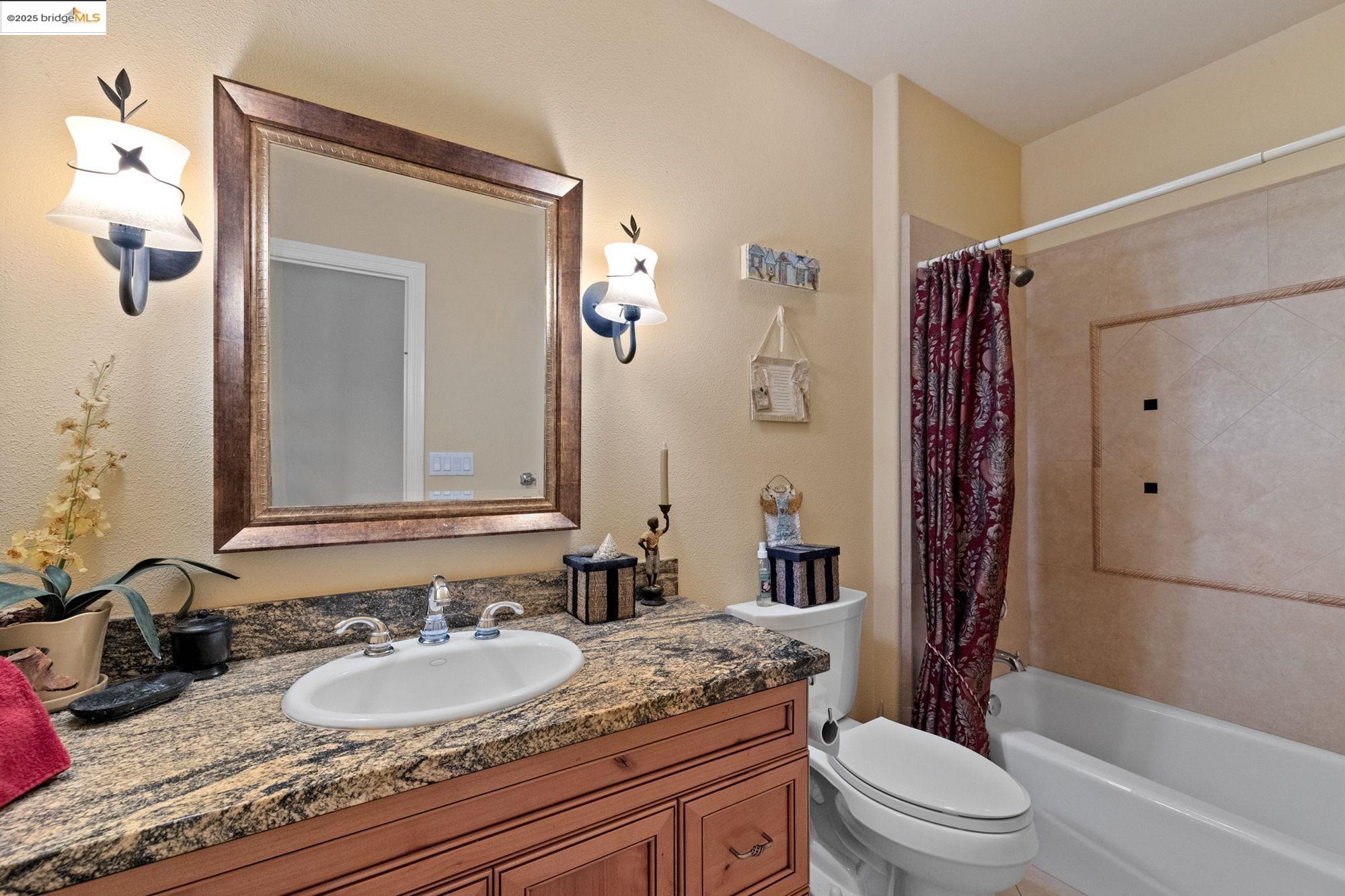 21190 Lyons Bald Mountain Road Sonora, CA 95370 - Photo 29 of 49 a bathroom with a granite countertop sink toilet a mirror a vanity and shower