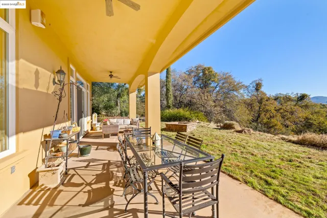 a view of a patio with table and chairs with wooden floor and fence