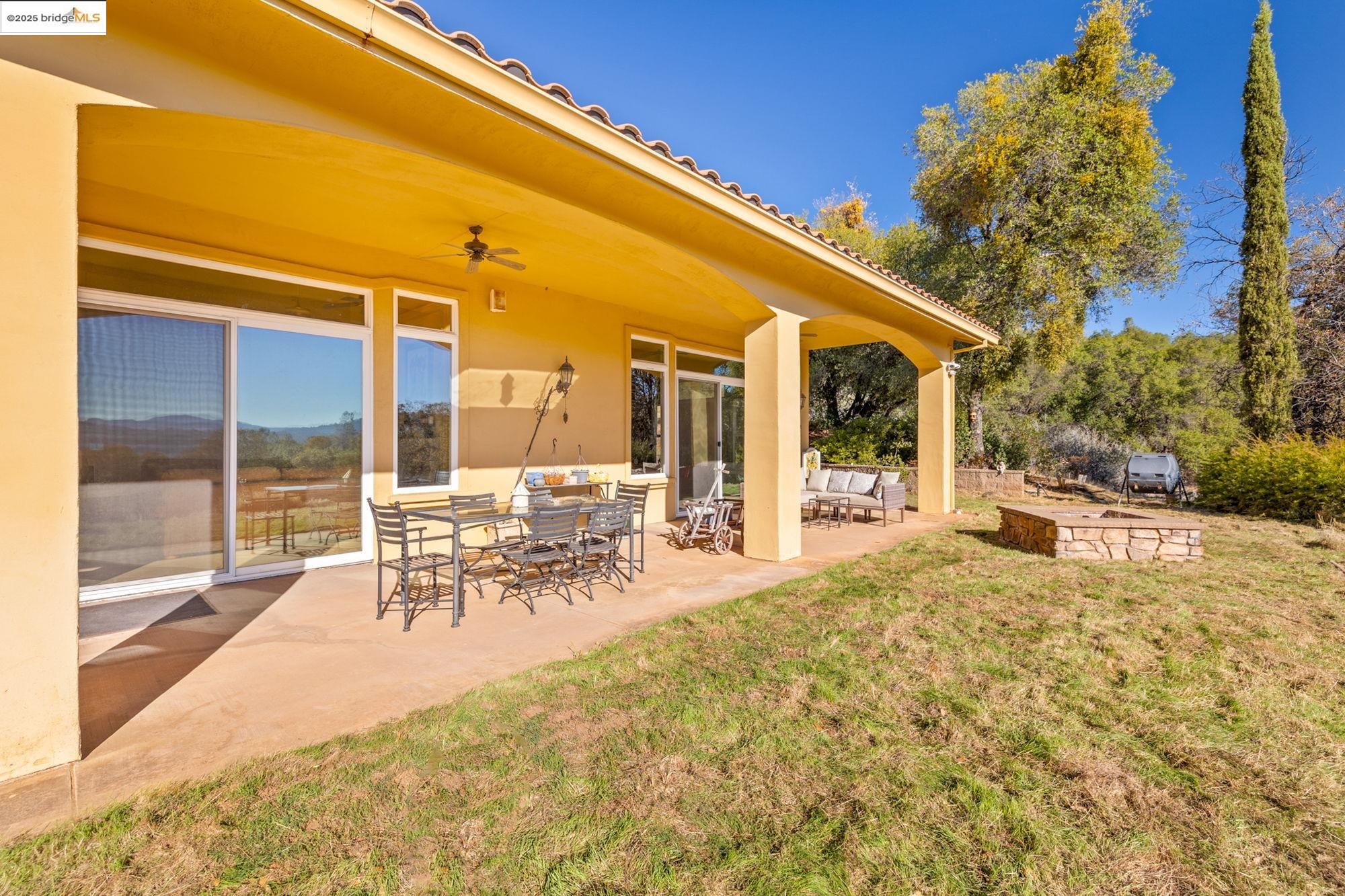 21190 Lyons Bald Mountain Road Sonora, CA 95370 - Photo 37 of 49 a view of a patio with table and chairs with wooden floor and fence