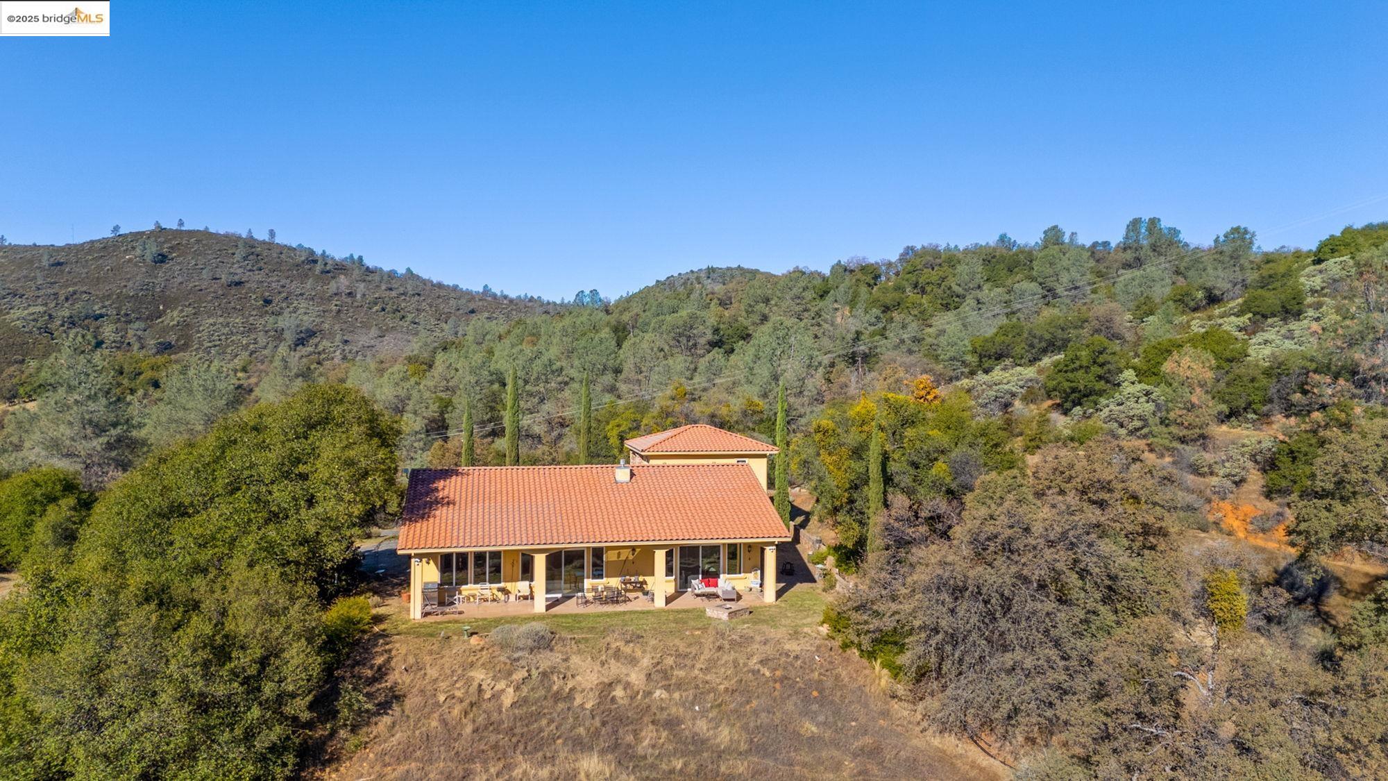 21190 Lyons Bald Mountain Road Sonora, CA 95370 - Photo 40 of 49 a view of a big house with a mountain in the background