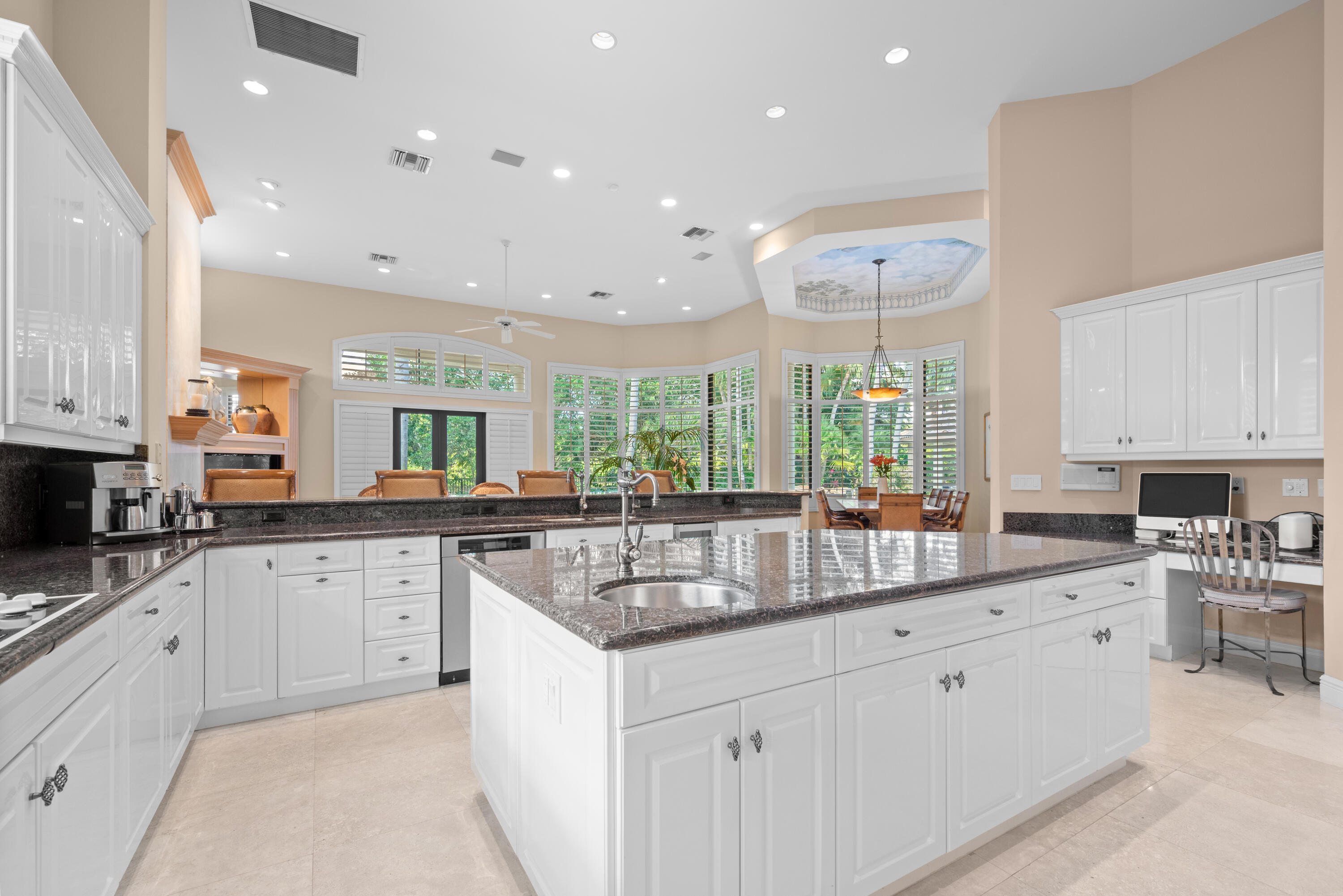 18800 Long Lake Drive Boca Raton, FL 33496 - Photo 17 of 60 a kitchen with granite countertop white cabinets white appliances a sink and a large window