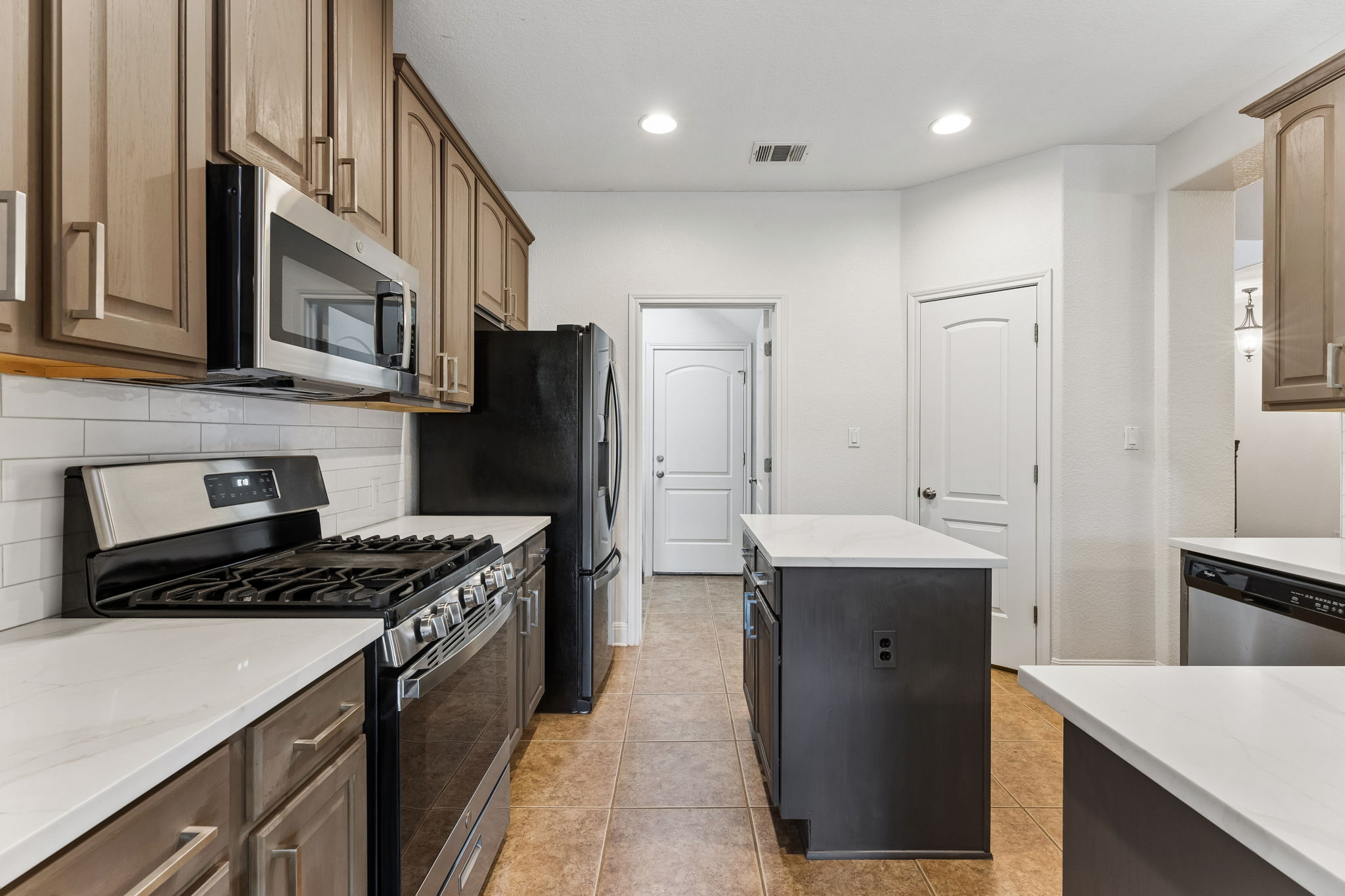 114 Aria Ridge, Unit 802 Lakeway, TX 78738 - Photo 6 of 37 Culinary aspirations come to life in this kitchen, featuring stainless steel appliances and an inviting island.