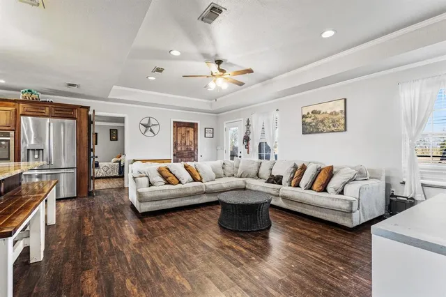 a living room with furniture kitchen view and a large window