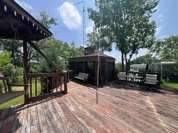 a backyard of a house with wooden floor fence and trees