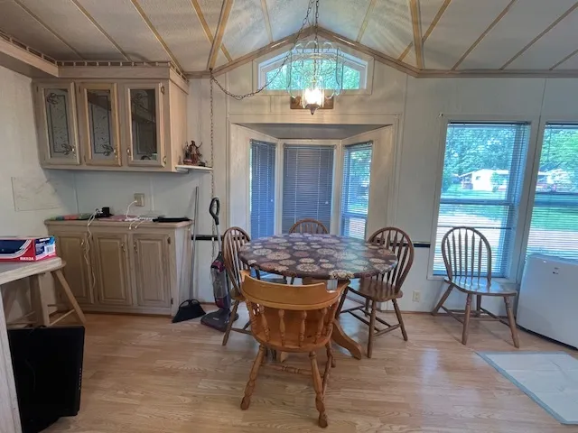 a view of a dining room with furniture a chandelier and wooden floor