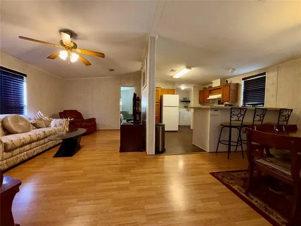 a living room with furniture a dining table and kitchen view
