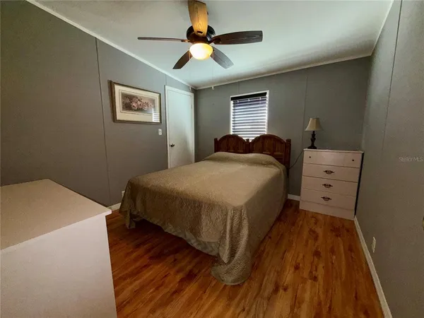 a bedroom with a bed and a ceiling fan