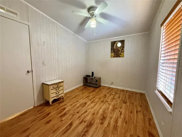 a view of a room with wooden floor and a window