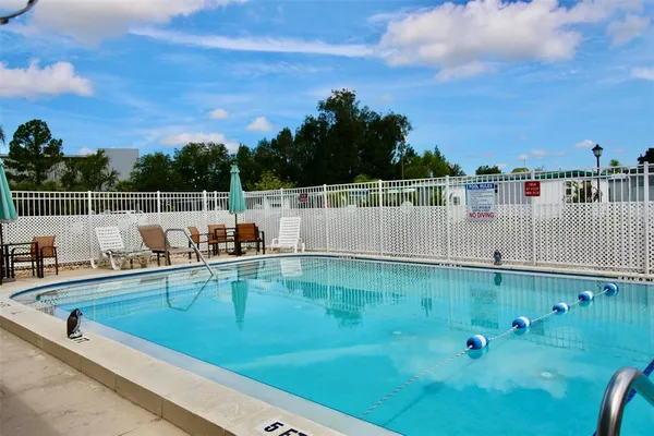 a view of a swimming pool with a patio and a yard