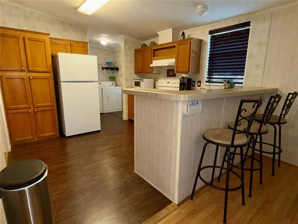 a kitchen with refrigerator and chairs